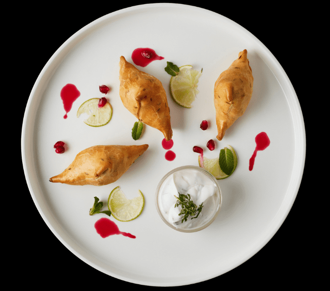 Oven air fried vegetable samosa with sour cream, lime and cranberry sauce